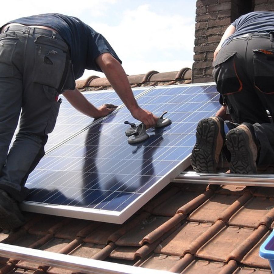 men fixing rooftop solar panels